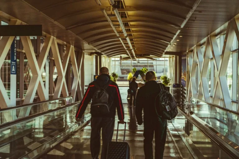 Travelers with luggage walking through an airport terminal