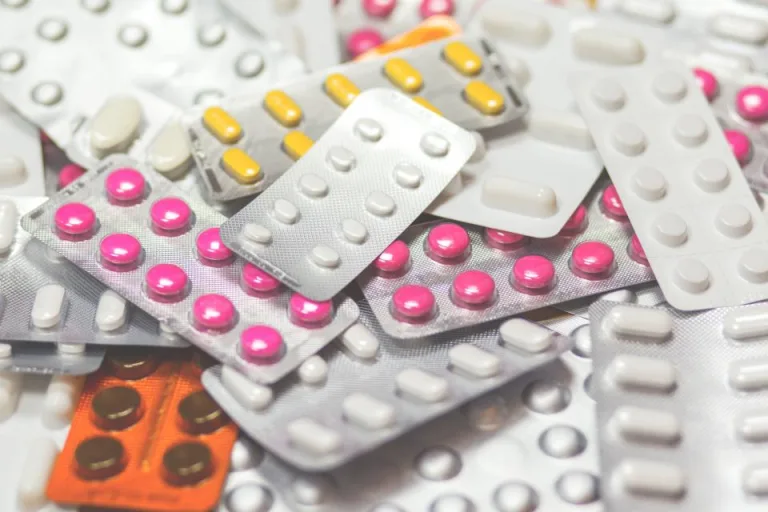Blister packs of colorful tablets piled on a table