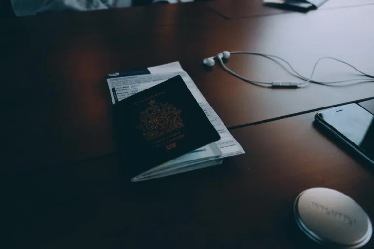 A passport and travel documents resting on a dark wooden desk
